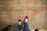 Textural detail of vintage distressed Oushak runner: worn pile, pale blush, terracotta, and sand.