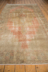 Secured end of the distressed Oushak runner, showing geometric patterns and soft colors.