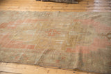 Close-up: Distressed vintage Oushak rug runner with stepped pattern, pale blush, beige, and worn texture.
