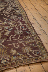 Time-softened aubergine Oushak rug with rams horn vinery and an intricate floral border.