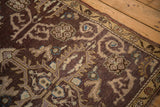Aubergine and beige rams horn vinery with aqua accents on a distressed Oushak rug.