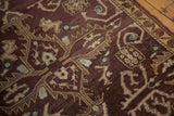 Distressed aubergine field with beige rams horn scrolling vinery on a Turkish Oushak rug.