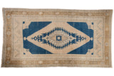 Vintage Distressed Oushak rug, navy blue and sand geometric medallion with pinwheel motif.