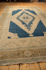 Distressed vintage Oushak rug featuring navy geometric medallion and pale bronze border.