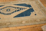 Distressed Oushak carpet with even wear, faint foundation, muted beige and navy tones.