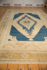 Distressed Oushak rug, worn beige field with navy and pale bronze geometric borders.