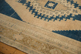 Worn texture on a distressed vintage Oushak carpet with beige and navy geometric pattern.