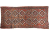 Distressed Oushak runner with cherry red, faded rust, charcoal diamond medallions, even wear.
