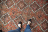 Distressed Oushak runner, geometric diamond medallions with faded cherry red texture.