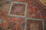 Worn texture of distressed Oushak runner pile, featuring faded rust and charcoal geometric diamonds.