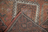 Distressed Oushak rug's worn pile, secured edge, and hand-knotted foundation.