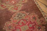 Textured pile of vintage Oushak runner, showing even wear and abrashed aubergine, rose, beige patterns.