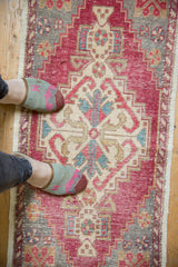 Overhead view of distressed Oushak runner with central medallion, showing reds, ivory, and gray wear.