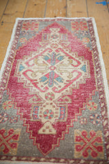 Distressed Oushak rug displaying low pile, stepped medallion, and blush cherry red with ivory tones.