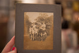 The antique donkey photograph held at an angle, showing its gray cardboard frame.