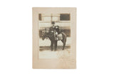 Antique sepia photograph of child on horse, man, small rug under saddle, with visible mat staining.