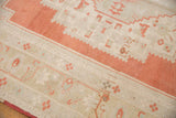Vintage distressed Oushak rug featuring softened burnt orange and ivory geometric patterns.
