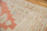 Distressed Oushak carpet, with decorative faded burnt orange and antique ivory motifs.