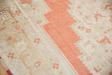 Detail of vintage Oushak rug; burnt orange jagged border, soft ivory field, faded motifs.