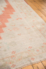 Distressed pile texture with softened burnt orange motifs on a vintage Oushak rug.