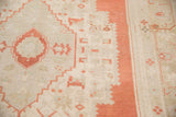 Distressed plush pile texture of a vintage Oushak, with burnt orange geometric motifs.