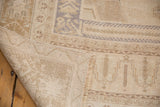 Distressed vintage Oushak rug corner, revealing worn pile, hand-knotted foundation, and secured edge.