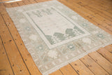Distressed ivory field with wide banded border in platinum, powder blue, and oxidized silver.