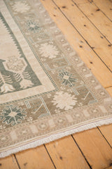 Distressed vintage Oushak rug border, with muted ivory floral patterns and fringe.