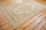 Distressed Oushak rug corner with pale blue, ivory, beige geometric floral spandrel.