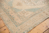 Vintage distressed Oushak rug corner with pale ocean blue geometric spandrel and low pile.