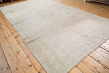 Distressed vintage Oushak rug with low pile, subtle ivory geometric medallion, and abrashes.
