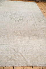 Distressed Oushak rug showing low pile and even wear, with subtle ivory geometric patterns.