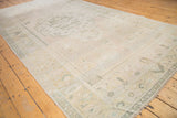Distressed vintage Oushak carpet edge showing low pile, foundation, and faded geometric patterns.