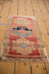 Distressed Oushak rug with abrashed raspberry field, geometric medallion, and fringed end.