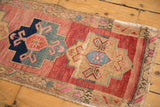 Distressed Oushak rug detail: navy and blush geometric medallion with primitive florals.