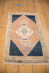 Vintage distressed Oushak rug corner showing worn pile, secure fringe, and geometric navy border.