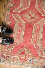 Distressed Oushak rug with soft raspberry red pile, beige sprawling leaf motifs.