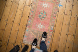 Distressed Oushak runner showing its hexagonal geometric medallion and faded blush, ocean blue tones.