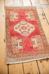 Distressed Oushak rug mat corner with short fringe, blush field, and plant motifs.