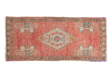 Distressed Oushak rug runner with blush field, ivory serrated medallion, and turquoise-orange accents.