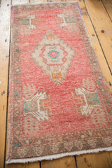 Vintage distressed Oushak rug's blush pile, coffee border, germinating plant motif, and fringe.