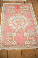 Vintage distressed Oushak rug in blush and ivory, showing wear and serrated medallion.