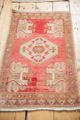 Patinaed texture and original selvage of vintage Oushak rug with raspberry, pink, beige patterns.