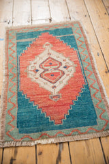 Vintage distressed Oushak rug corner, with fringe and mint green wavy border pattern.