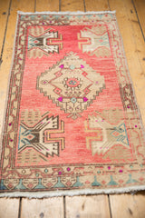 Distressed Oushak rug detail: central beige serrated medallion, stylized plants on faded blush field.