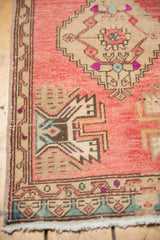 Distressed Oushak rug corner, beige germinating plant motif on blush field with blue.