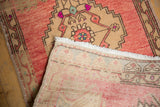 Hand-knotted vintage Oushak rug's foundation and distressed blush, beige pile.