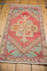 Distressed pile of vintage Oushak rug showing blush, mint green, and pale raspberry hues.