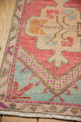 Distressed vintage Oushak rug corner detail, showing even wear, blush, mint, ivory patterns, fringe.