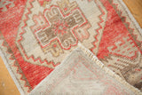 Distressed Oushak rug showing its worn pile, fringe, and hand-woven reverse.